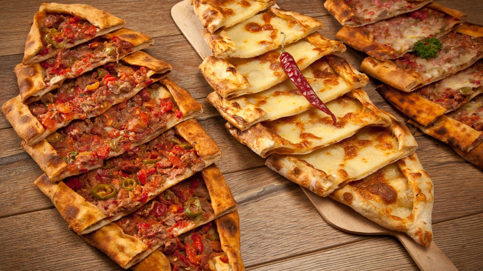 Traditional Turkish pides sliced on wooden boards